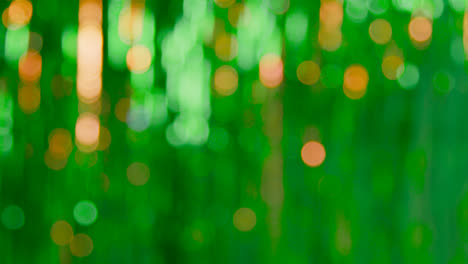 Defocused-Full-Frame-Background-Shot-Of-Green-And-Gold-Tinsel-In-Studio-For-St-Patrick's-Day